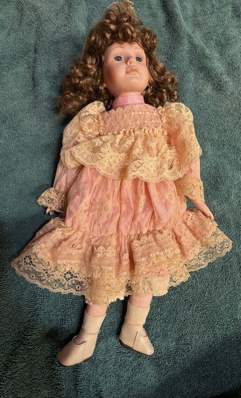 Vintage Collectible Porcelain Doll with Brown Curly Hair and Pink Lace Dress